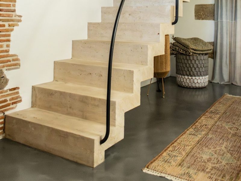 Escalier crémaillère massif en pierre de taille avec palier double niveaux